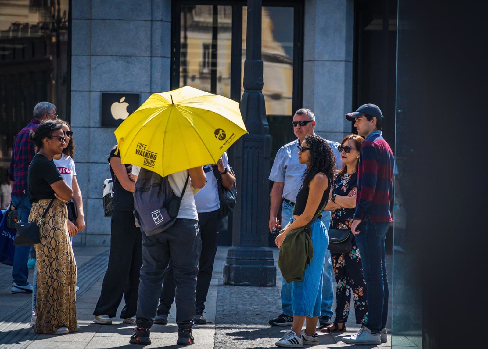 Grupo de un free tour de Trip Tours bajo el paraguas amarillo en Madrid